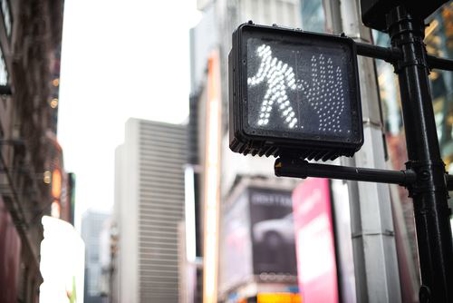 pedestrian crossing sign on street light