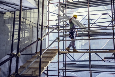 man walking across scaffold